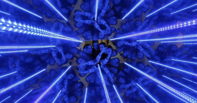 Three women are seen through a giant kaleidoscope as they look inside, as the exhibit is on display to demonstrate the geometric effect of filling space with equal triangles at the “Newton Park” interactive museum of science, during preparations for a performance for school children dedicated to the Russian Day of Science at the Museum Centre in Krasnoyarsk, Siberia, February 4, 2015. REUTERS/Ilya Naymushin 